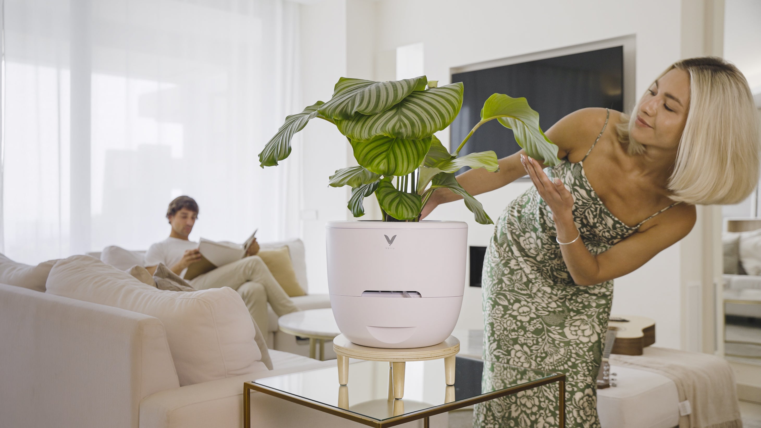 Woman contentedly enjoying her Verta Air Purifier, placed on top of the assembled wooden table stand for enhanced aesthetics and functionality.